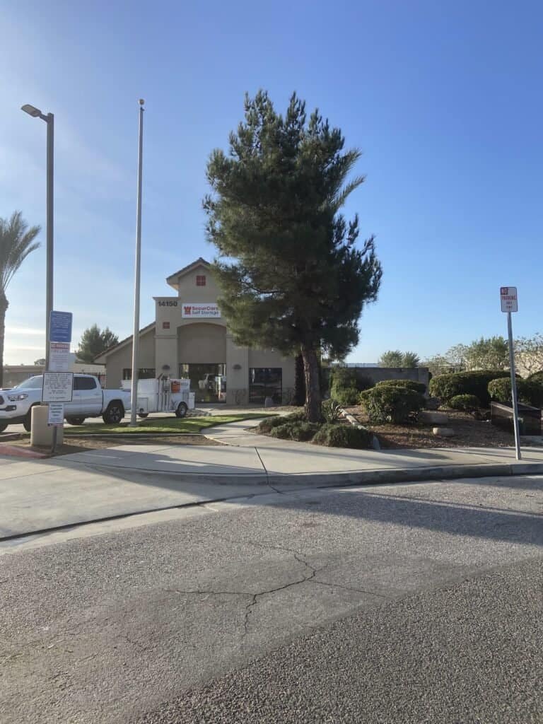 Beautiful landscaped commercial property with trees and shrubs in front of a building.