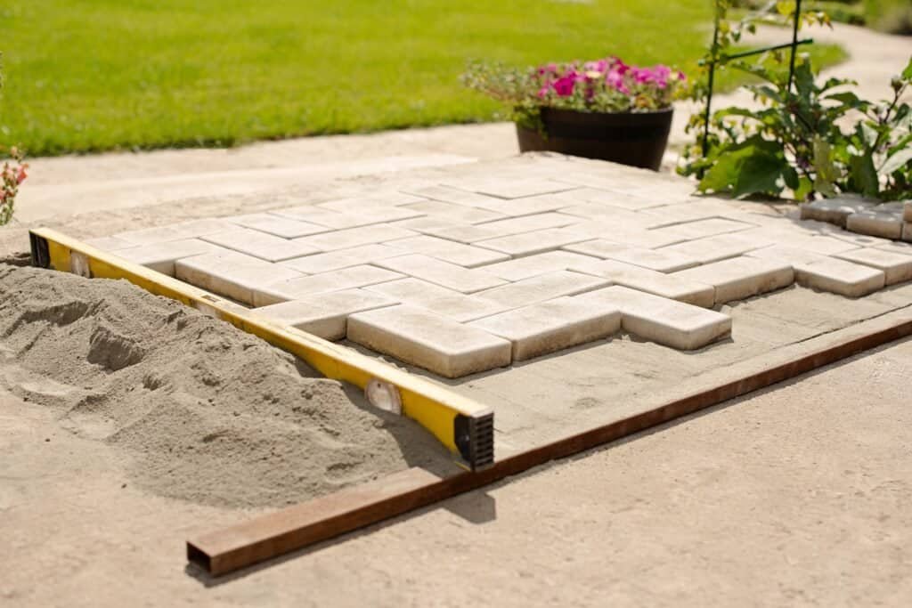 Landscaping paver pathway construction with precision leveling, ideal for outdoor upgrades.